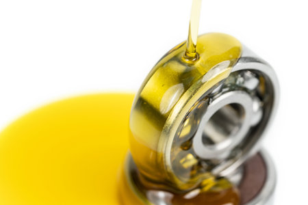 Closed up macro, Pouring automotive engine oil into ball bearing isolated on white background with copy space, engineering and industrial concept. Motor oil on bearingの写真素材