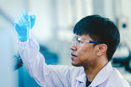 Medical Research Laboratory: Portrait of a asian male Scientist in Goggles Using Micro Pipette for Test Analysis. Advanced Scientific Lab for Medicine, Biotechnology, Microbiology Developmentの写真素材