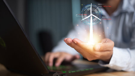 Close up of businessman hand pointing at cellphone with glowing digital wind mill turbine hologram. Wind generator concept.の写真素材