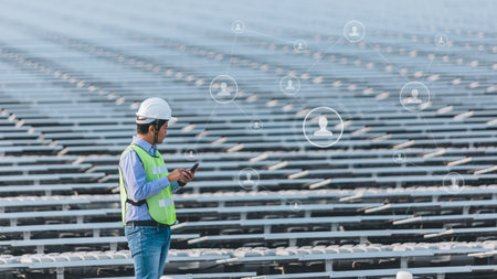 overhead view of engineer in helmet using smartphone while standing at stadiumの写真素材