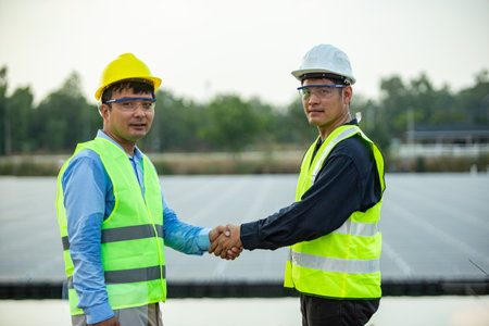 Two engineers shaking hands at solar power plant. Engineering and construction concept.の写真素材