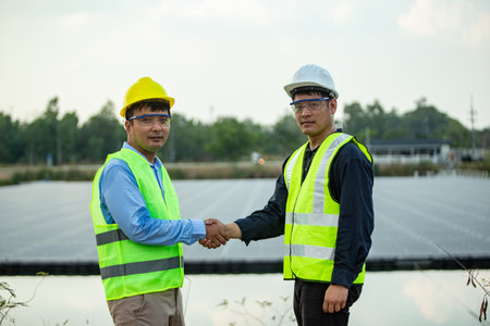 engineer and technician shaking hands in solar power plant, business conceptの写真素材
