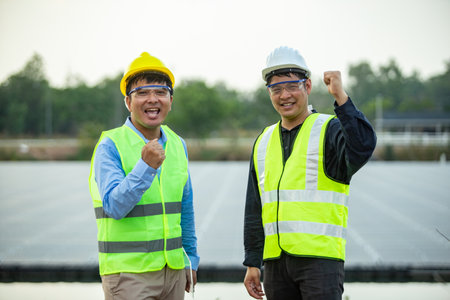 Engineer and technician are standing in front of solar power plant.の写真素材