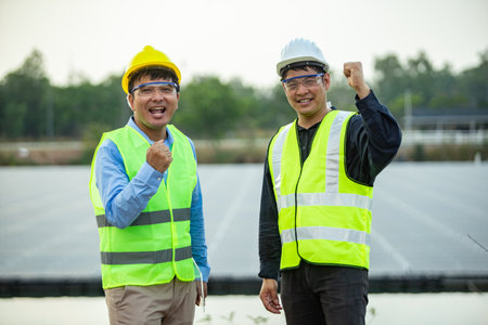 Asian engineer and technician on a solar power plant with success gesture.の写真素材