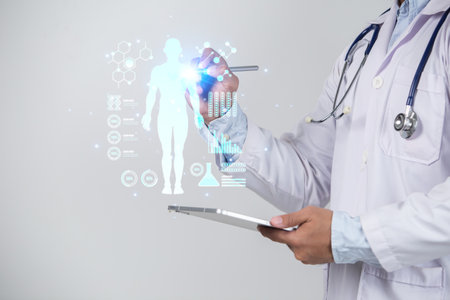 Doctor using tablet computer with medical hologram over white background. Healthcare and medicine conceptの写真素材