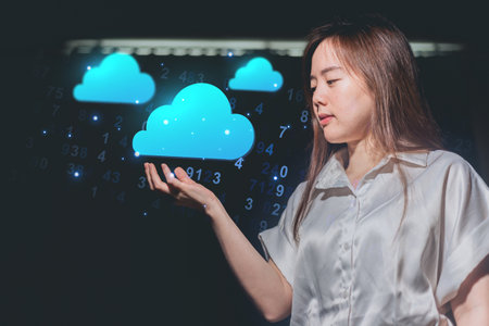 Young businesswoman working with cloud computing concept on dark background. Double exposureの写真素材