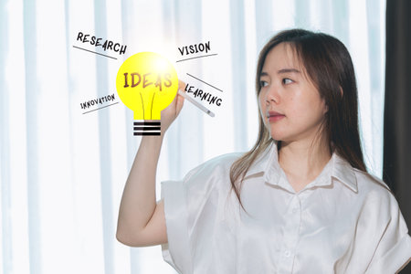 Young businesswoman thinking about idea in light bulb. Idea concept.の写真素材
