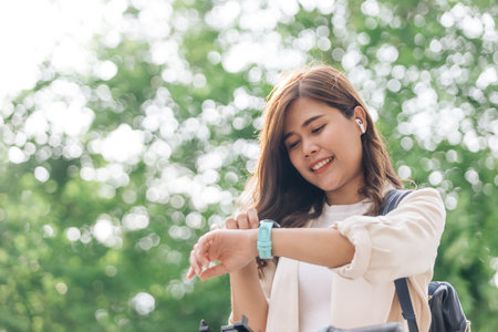 Beautiful asian woman using smart watch in the park, technology conceptの写真素材