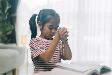 Little asian child girl praying for god  at home.の写真素材