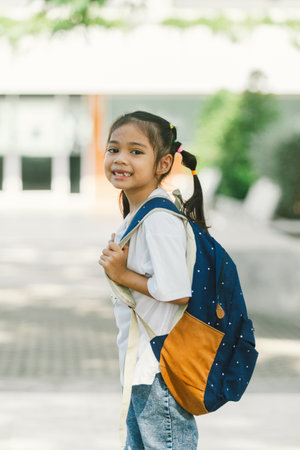 Portrait of cute little asian schoolgirl with backpack in the schoolの写真素材