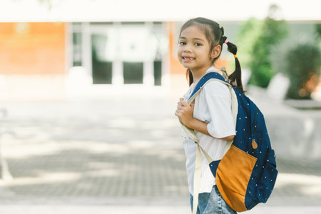Portrait of cute little asian schoolgirl with backpack at schoolの写真素材