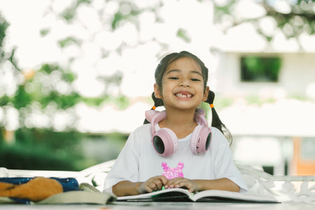 Happy asian girl reading book in the garden. Education concept.の写真素材