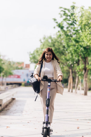 asian woman riding electric scooter in the park, lifestyle conceptの写真素材