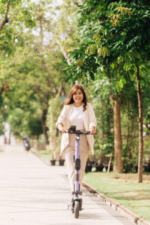 asian woman riding electric scooter in the park, lifestyle conceptの写真素材