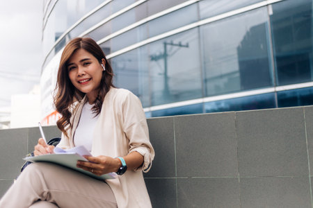 Beautiful business woman with notebook and pen in the city outdoor.の写真素材
