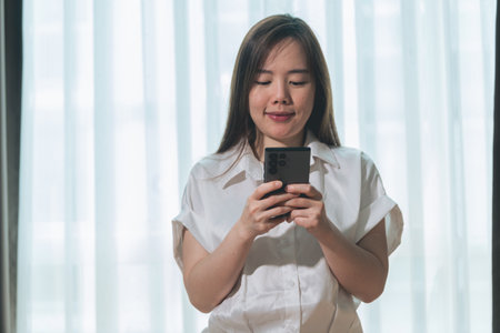 Beautiful asian businesswoman using mobile phone in the office.の写真素材