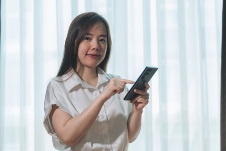 Young asian businesswoman using tablet computer in office room. Business and technology concept.の写真素材