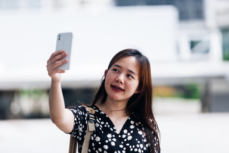 Young woman wearing face mask and using mobile phone in the city.の写真素材