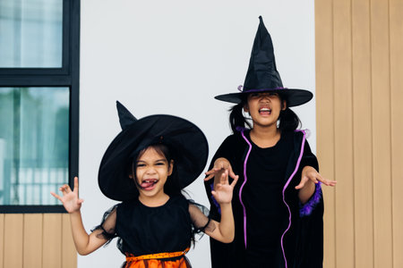 asian little girls in halloween costumes having fun at home