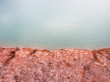 Pure aqua basin with red cracked dirt