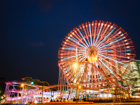Amusement park at night - Ferris wheel and roller coasterの写真素材