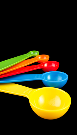 Set of expanding measuring spoon isolated against black backgroundの写真素材