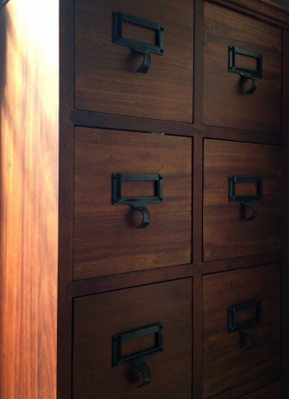 Rows of little drawers with white empty tags in an old furniture moduleの素材