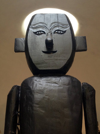 An ancient sculpture of man mad out of wood の写真素材