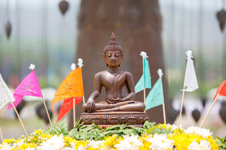 A Buddha statue covered with flower petalsの写真素材