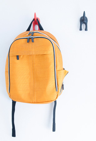 Orange backpack on the wallの写真素材