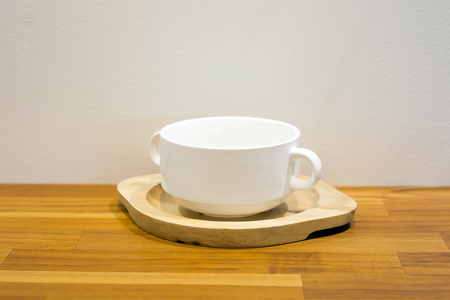 Cup of coffee with wooden tray on wooden table backgroundの写真素材