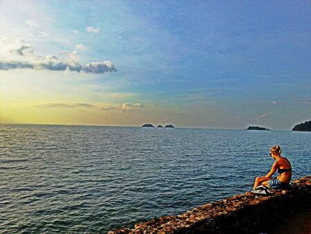 Sexy girl sitting by the seaの素材