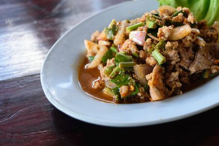 Ground pork salad in dish on wood tableの写真素材