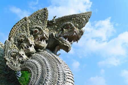 Serpent or naga statue head with blue sky backgroundの写真素材