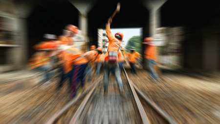 Blurred zoom of  Railway employees working for restoration the railroad tracks before serving at State Railway of Thailand.の写真素材