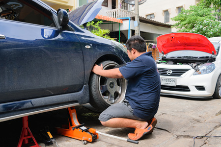 Bangkok, Thailand - August 30, 2015 : Unidentified serviceman checking suspension in a car at garageのeditorial素材
