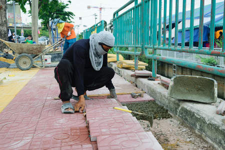 Bangkok, Thailand - September 11, 2015 : Unidentified worker laying paver bricks paver making sidewalkのeditorial素材