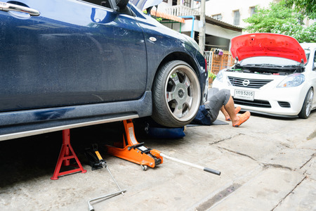 Bangkok, Thailand - August 30, 2015 : Unidentified serviceman checking suspension in a car at garageのeditorial素材