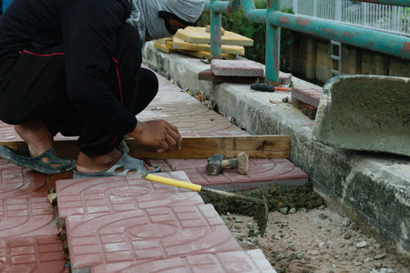 Bangkok, Thailand - September 11, 2015 : Unidentified worker laying paver bricks paver making sidewalkのeditorial素材