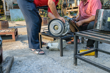 Bangkok, Thailand - April 5, 2015 : Unidentified two workers repair car truck part at garage.のeditorial素材