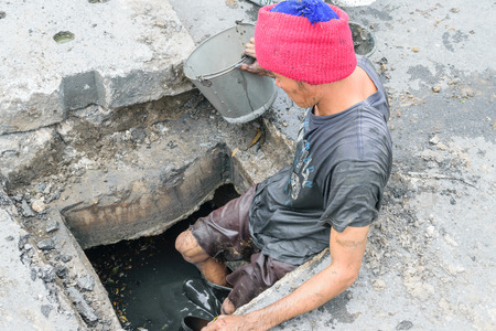 Bangkok, Thailand - October 11, 2015 : Unidentified worker working for drain cleaning. Problem with...