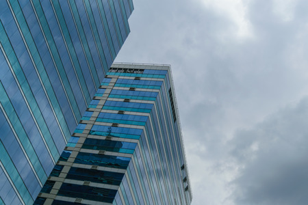 Big glass building with blue sky and storm cloudの写真素材