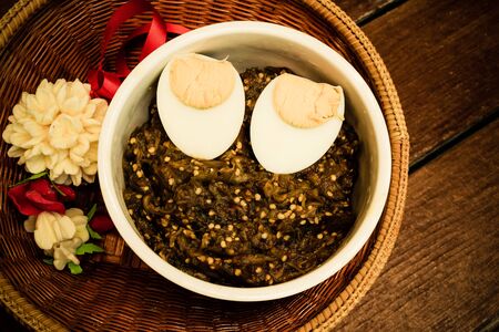 Thai food pound eggplant with boiled egg in white cup and jasmine garland made from soap in Thailand...