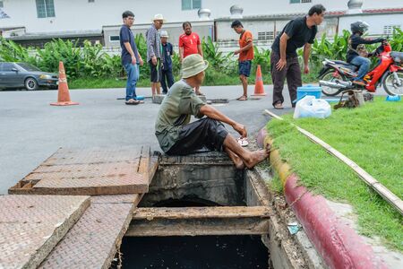 Bangkok, Thailand - October 17, 2015 : Unidentified worker working for drain cleaning. Problem with the drainage system.のeditorial素材