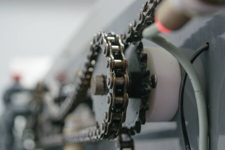 Sprocket chain on sheet offset machine draws paper in printeryの写真素材