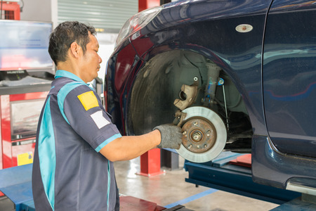 Bangkok, Thailand - January 16, 2016 : Unidentified serviceman checking brake system in a car at garageのeditorial素材