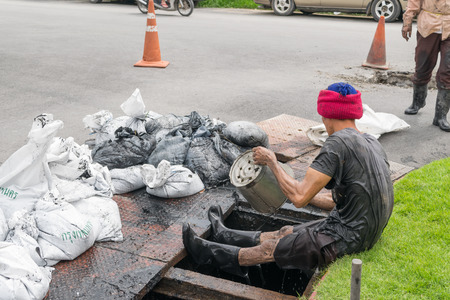Bangkok, Thailand - October 11, 2015 : Unidentified worker working for drain cleaning. Problem with the drainage system.のeditorial素材