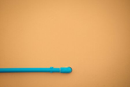 Minimalism style, Blue water pipe on yellow wall texture background. , process in vintage styleの写真素材