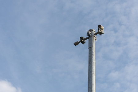 Security camera (CCTV) for safety on blue sky and city background