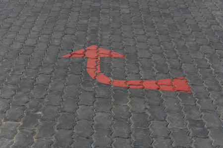 Arrow red sign paint on a brick road or walkway for turn right symbol